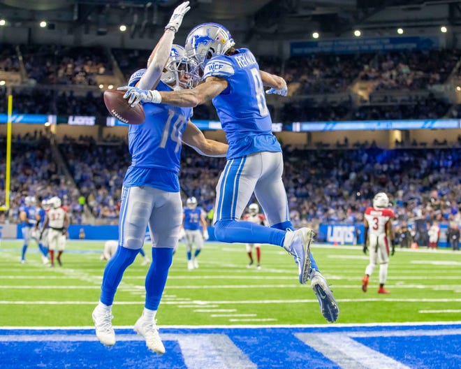 Lions wide receiver Josh Reynolds, right, celebrates his TD catch with receiver Amon-Ra St. Brown during the first half on Sunday, Dec. 19, 2021, at Ford Field.